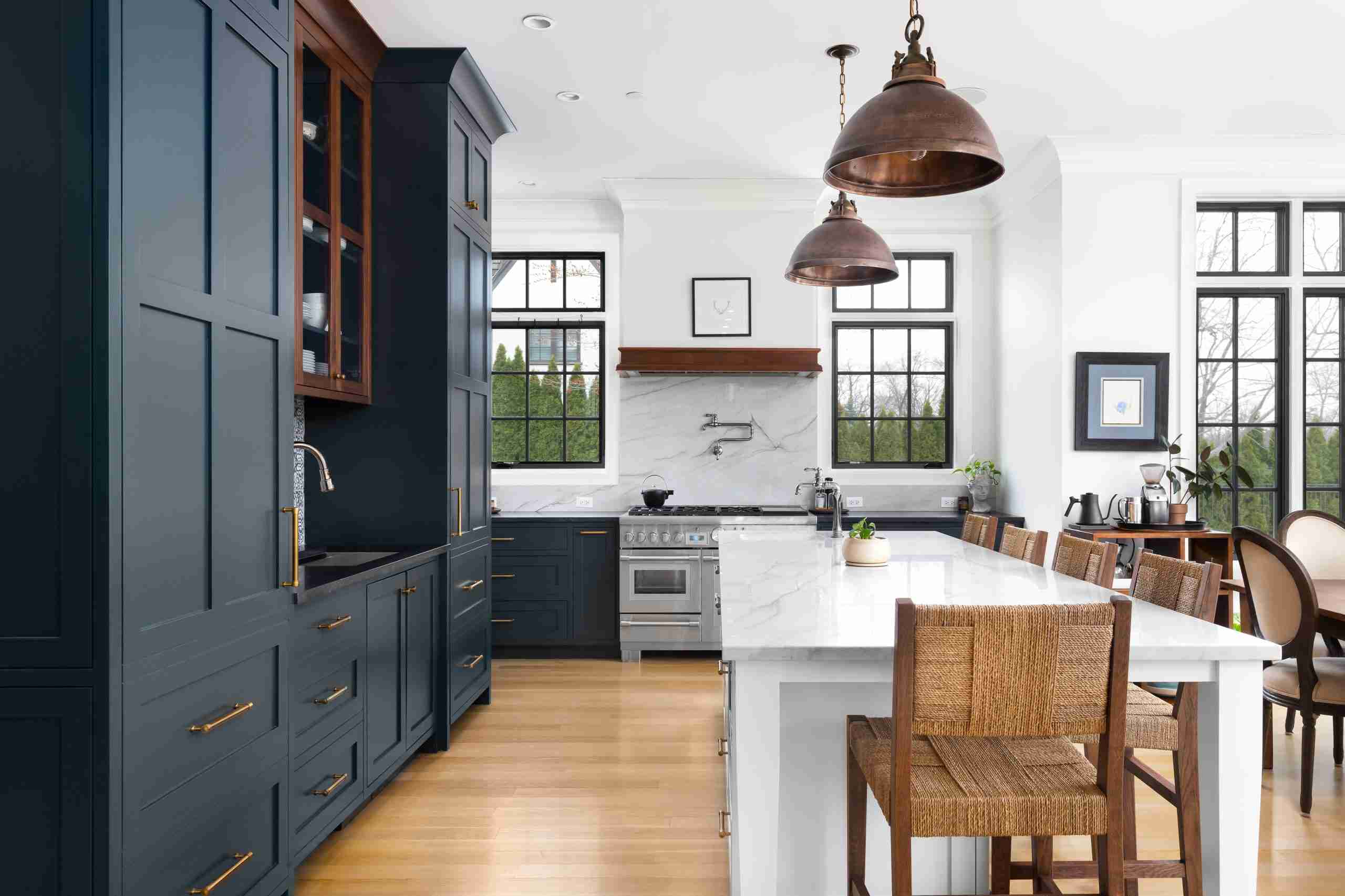 Modern traditional kitchen with dark cabinets and white counters. A kitchen with Mixed metals and wood textures giving a little cottage core vibe too.