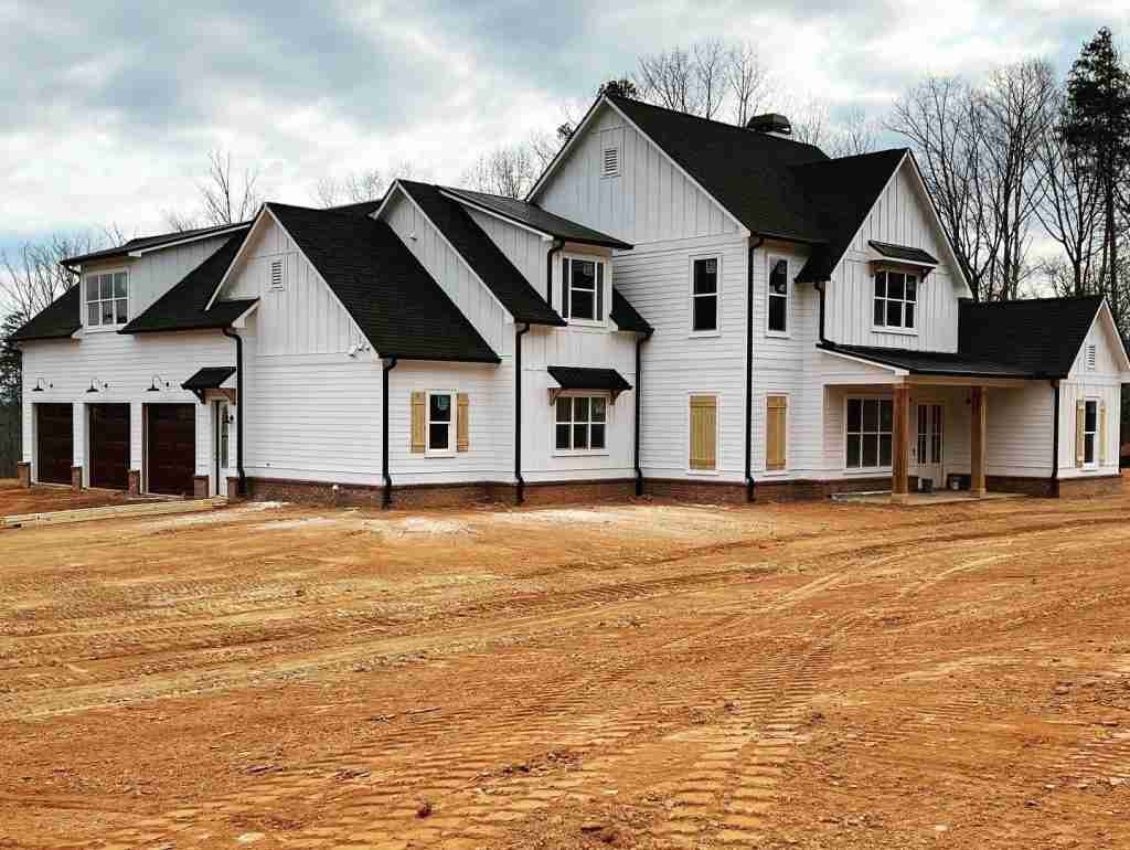 Large white modern farmhouse exterior with 3-car garage.