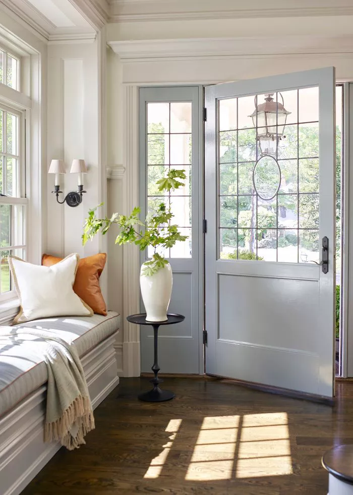 Modern Traditional interior design entryway with a glass front door, large windows and a bench seat.